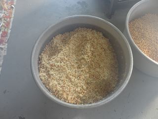 前日２回も混ぜたのに固くなっていた米麹に塩と煮た大豆を混ぜます。これをミンチにかけます。